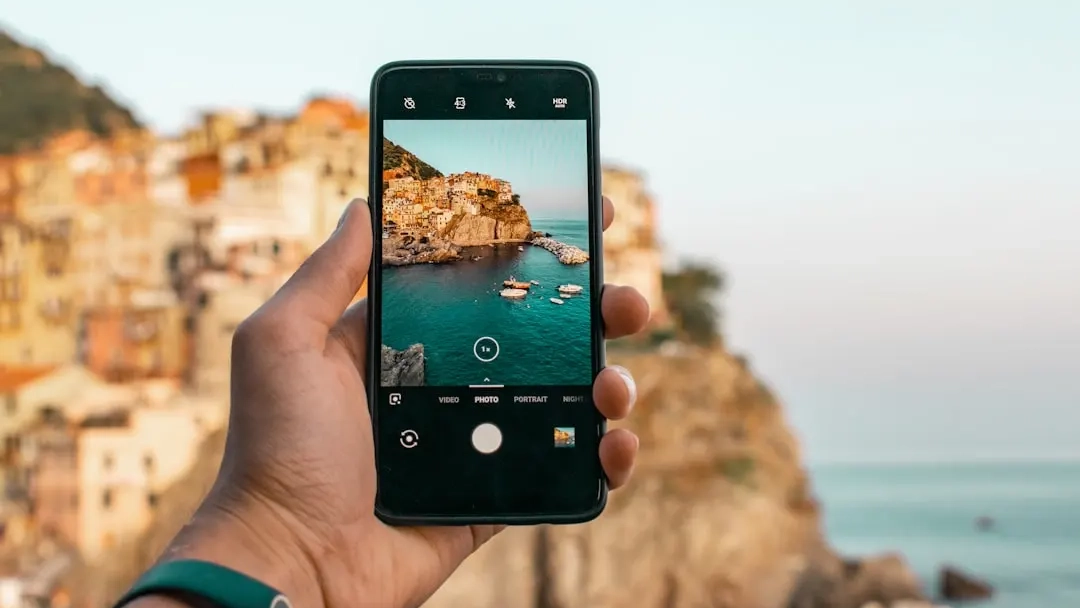 person holding a phone near cliff during daytime